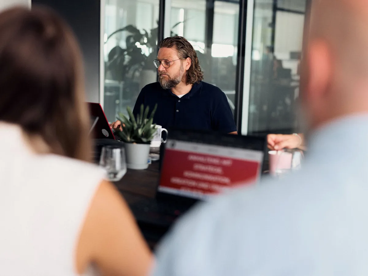 Mirco Welsing in einer Besprechung mit mehreren Personen an einem Konferenztisch