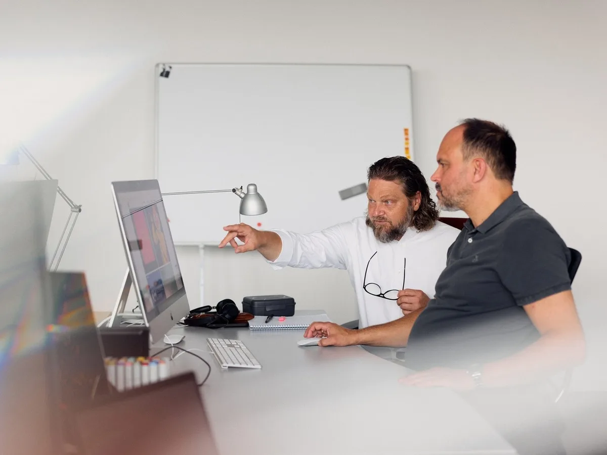 Mirco Welsing arbeitet mit einem Kollegen gemeinsam an einem Bildschirm